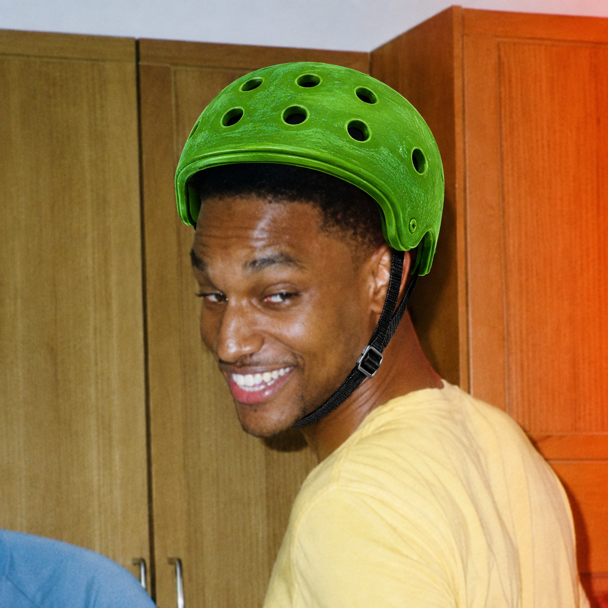A smiling man in real life wearing the $SPED green helmet